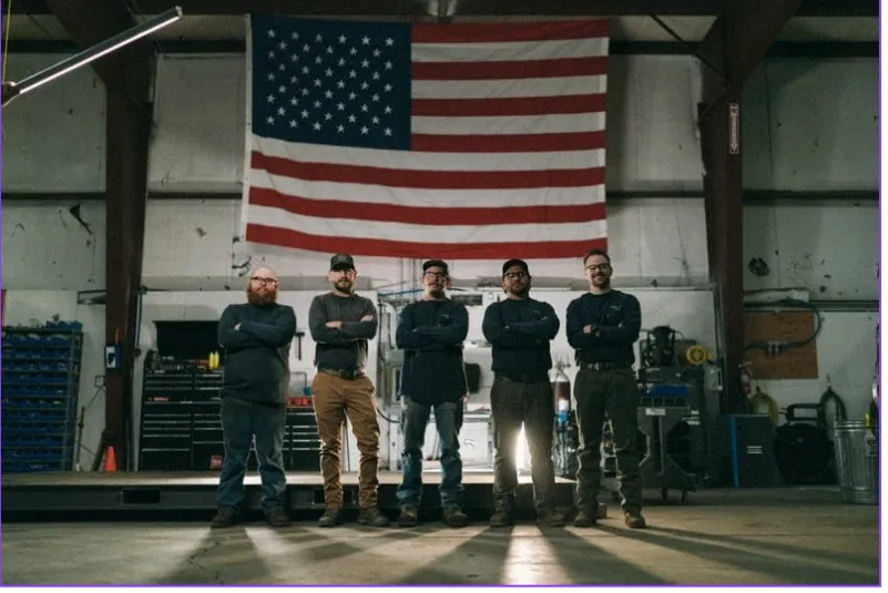 Innovations Manufacturing team standing in front of American flag